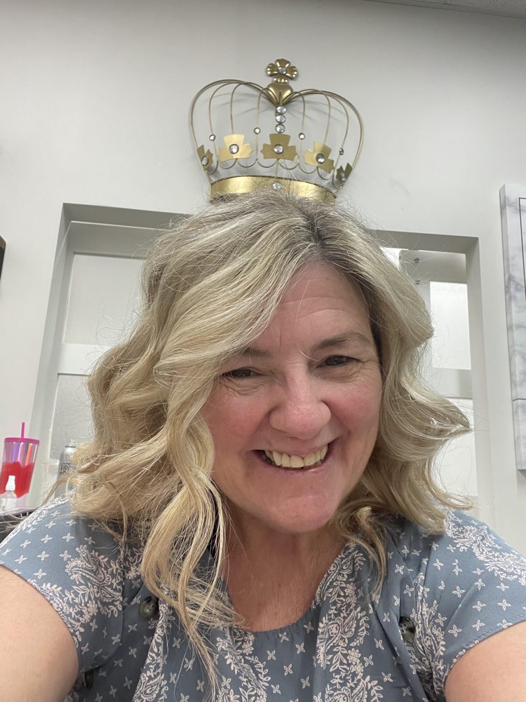 Tish wearing a gold crown, smiling